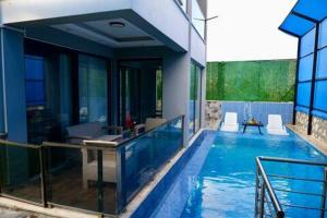 a swimming pool with chairs and a house at Mavi Apart in Demre