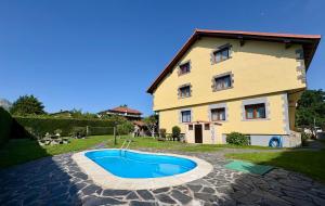 a house with a swimming pool in front of a building at La Casona El Carrascal in La Gandara