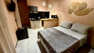 a small bedroom with a bed and a kitchen at Guajiru Beach House KiteSurf in Trairi