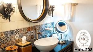 a bathroom with a sink and a mirror at Mansión del Cobre Hotel Boutique in Los Mochis +31 photos