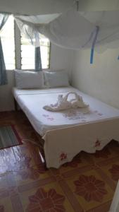 a bed in a room with a white bedvisor at VureVure Homestay in Mbouma