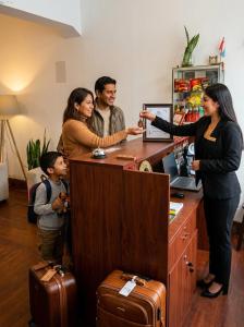 a group of people standing around a counter with a woman at SANCA HOUSE Hostel in Trujillo
