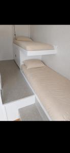 two white bunk beds in a small room at Studio cabine Canet Plage Parking in Canet-en-Roussillon +4 photos