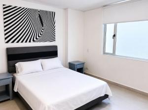 a bedroom with a white bed and a black and white painting at Luxury Suite with Pool in Melgar in Melgar +2 photos
