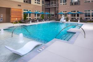 a swimming pool in a hotel with chairs and umbrellas at Spacious Apartment in Alexandria in Alexandria