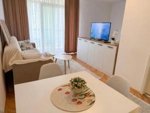 a living room with a table and a tv at Angel's Residence in Veles