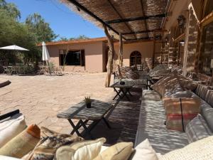 a patio with a bunch of couches and tables at Hotel Tulor in San Pedro de Atacama
