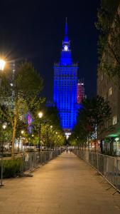 a tall building with blue lights on it at night at Centrum Warszawy - City Center the best places, metro Centrum & Świętokrzyska, partial view of the Palace of Culture, self check-in, AC, optional breakfest in Warsaw