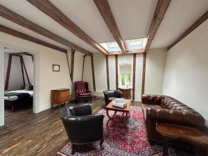 a living room with a leather couch and chairs at Liselund Ny Slot Hotel in Borre +48 photos