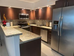 a kitchen with a stainless steel refrigerator and granite counter tops at Condominium Sunny Isles Ocean Reserve in Sunny Isles Beach