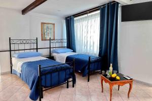 a bedroom with two beds and a window at Balcone sul Vesuvio in Vico Equense
