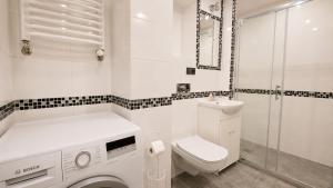 a white bathroom with a toilet and a sink at Centrum Warszawy - City Center the best places, metro Centrum & Świętokrzyska, partial view of the Palace of Culture, self check-in, AC, optional breakfest in Warsaw +12 photos