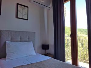 a bedroom with a bed and a window with a balcony at Zen Olive Retreat in Petrovac na Moru +38 photos