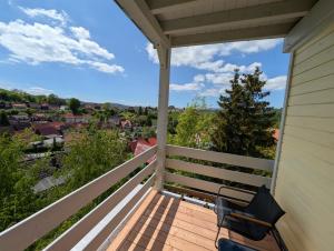 a balcony with a bench and a view of the city at Jessis Harz Appartements in Sankt Andreasberg