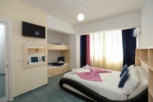 a bedroom with a bed with a tv and a window at Hotel Garden in Vlorë