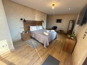 a bedroom with a bed and a wooden floor at Loft Elena en ValQuirico in Santeagueda