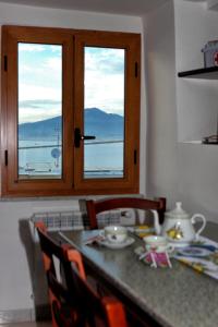 a kitchen with a table with a view of the ocean at Balcone sul Vesuvio in Vico Equense +41 photos