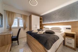 a bedroom with a large bed with a desk and a desk at Apartments Bajcic in Rab +110 photos