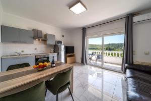 a kitchen with a table with a bowl of fruit on it at Apartments Bajcic in Rab