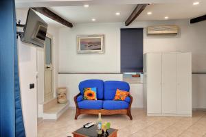 a blue chair with two pillows in a living room at Balcone sul Vesuvio in Vico Equense