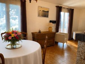 a living room with a table with a vase of flowers at Casa Minnana in Figari