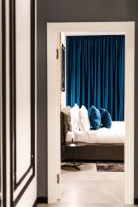 a bedroom with a bed and a blue curtain at OLD TOWN SNAIL Design Apartments in Bucharest