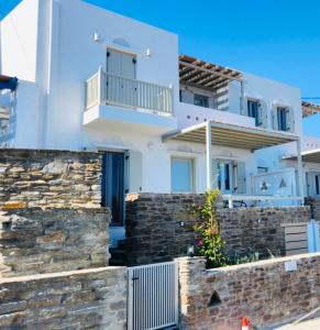 a white house with a stone wall at Arnados Residence in Kékhros