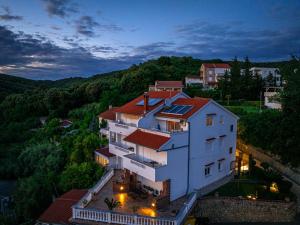 a large white building with a red roof at Apartments Bajcic in Rab