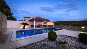 a swimming pool in the backyard of a house at Apartments Bajcic in Rab