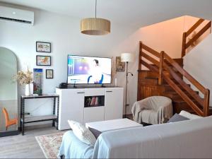 a living room with a couch and a tv at Zen Olive Retreat in Petrovac na Moru