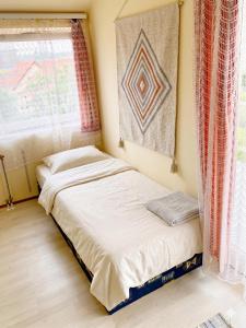 two beds in a room with a window at Lipták Vendégház in Balatonfüred