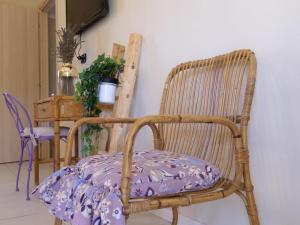 a wicker chair with a purple pillow on it at Chicche di Lavanda in Valmadonna