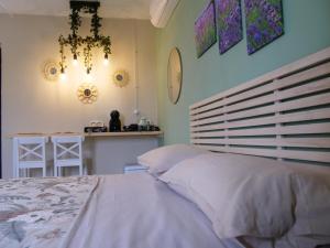 a bedroom with a bed and a table and a chandelier at Chicche di Lavanda in Valmadonna