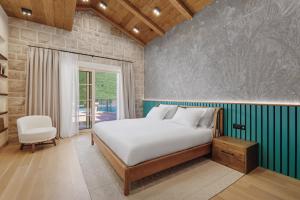a bedroom with a bed and a chair at MiraMare in Luštica +42 photos