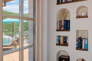 a room with a window with bookshelves at MiraMare in Luštica