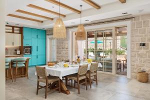 a dining room with a white table and chairs at MiraMare in Luštica