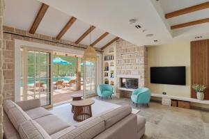 a living room with a couch and a tv at MiraMare in Luštica