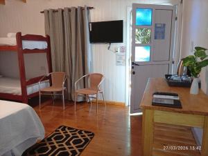 a bedroom with a bed and a table and chairs at Alojamiento mei-mei in Puerto Iguazú