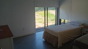 a bedroom with a bed and a large window at lazy beach in Punta del Este +20 photos