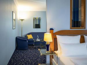 オーバーディングにあるAtomis Hotel Munich Airport by Mercureのベッドとソファのあるホテルの部屋