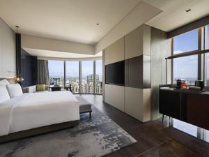 a bedroom with a white bed and a large window at Pullman Quanzhou Shuitou in Quanzhou