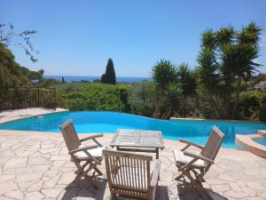 a patio with a table and chairs next to a pool at Chambre Bed and Breakfast dans la Villa Cypra in Antibes