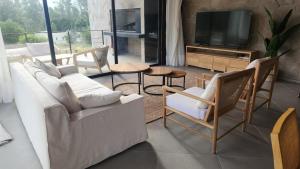 a living room with a couch and chairs and a television at lazy beach in Punta del Este