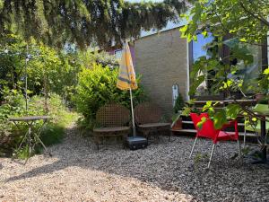 a group of chairs and an umbrella in a garden at Apartment Osso 2, Arnhem in Arnhem
