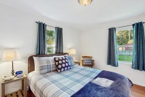 a bedroom with a bed and two windows with blue curtains at Eagle Harbor House World Cup Availability in Winslow