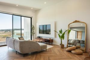 a living room with a couch and a mirror at Villa Aurora Luxury Villa with Infinity Pool in Portimão