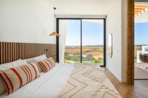 a bedroom with a large bed with a large window at Villa Aurora Luxury Villa with Infinity Pool in Portimão +38 photos