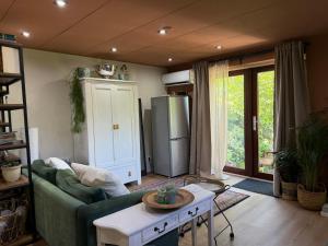 a living room with a green couch and a refrigerator at Apartment Osso 2, Arnhem in Arnhem