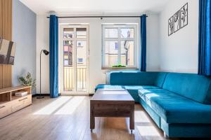 a living room with a blue couch and a table at Plac Solny 4 Discreet&Comfort Głogów in Głogów