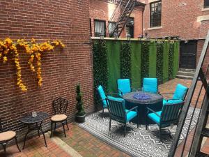 a patio with blue chairs and a table on a brick wall at Beacon Hill Nights in Boston
